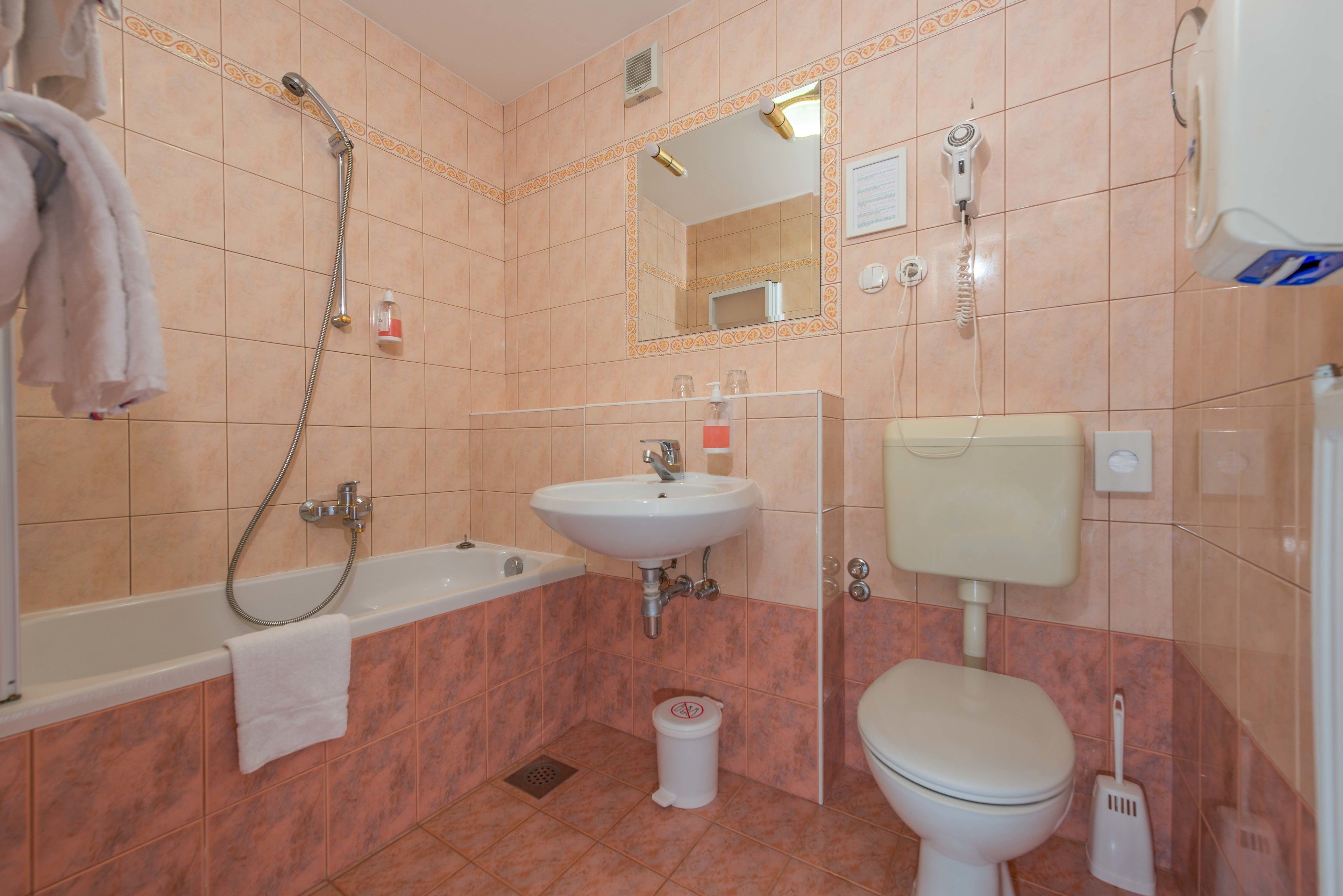 A bathroom with a bathtub, sink, toilet, and shower.