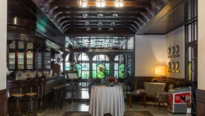 Vestíbulo de hotel con zona de bar, asientos y una máquina de café.