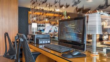 A modern office desk with a computer, keyboard, and mouse, a lamp, and a chair.