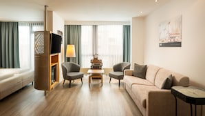 Una sala de estar moderna con sofá, dos sillones, una mesa de centro, televisor y chimenea.