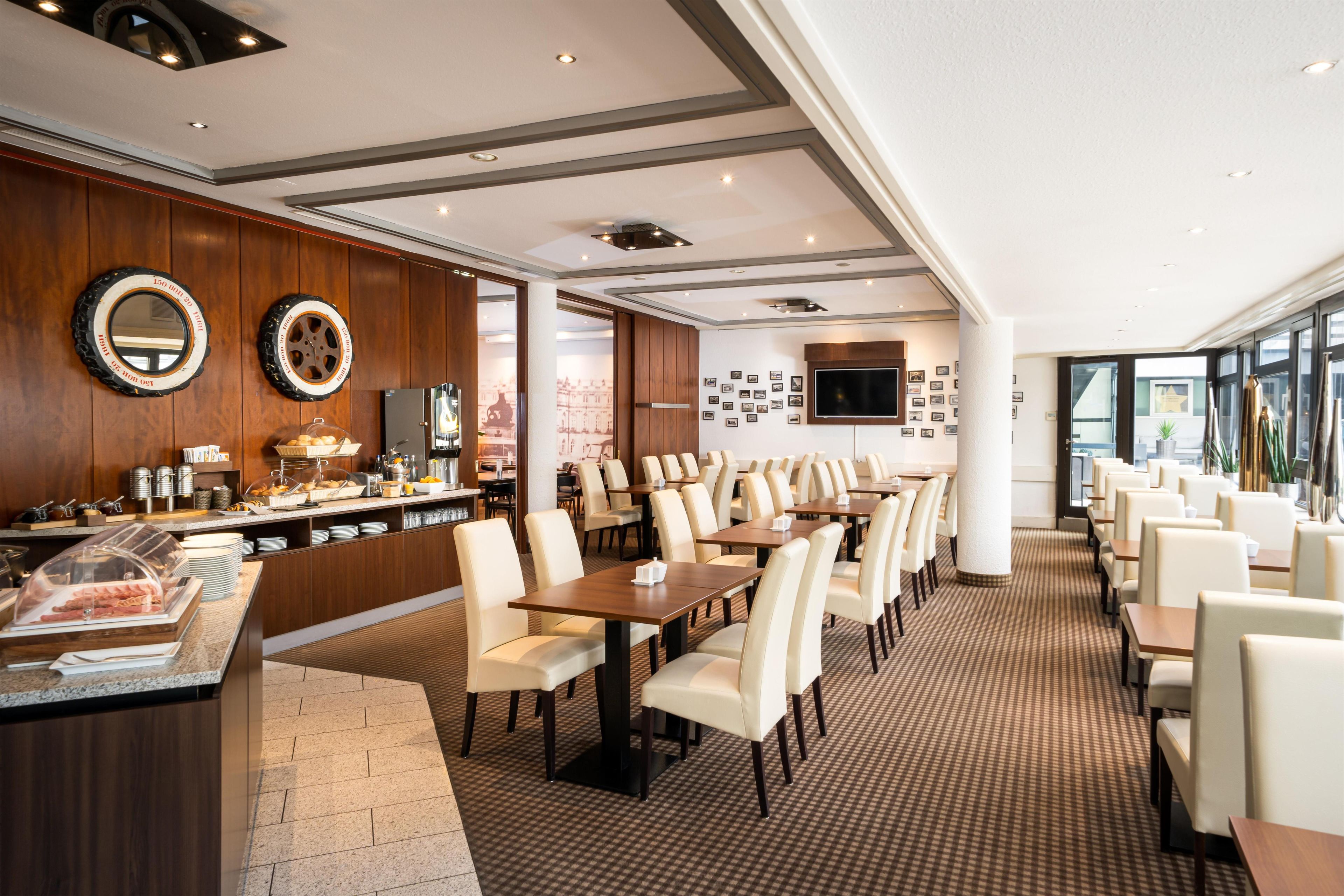 Ein Hotel-Essbereich mit einem Buffet, mehreren Tischen und Stühlen.