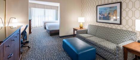 Une chambre d’hôtel avec un lit, un canapé, un bureau et une chaise.