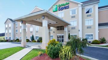 Welcome to the Holiday Inn Express, featuring a modern entrance with a covered walkway and beautifully maintained grounds.