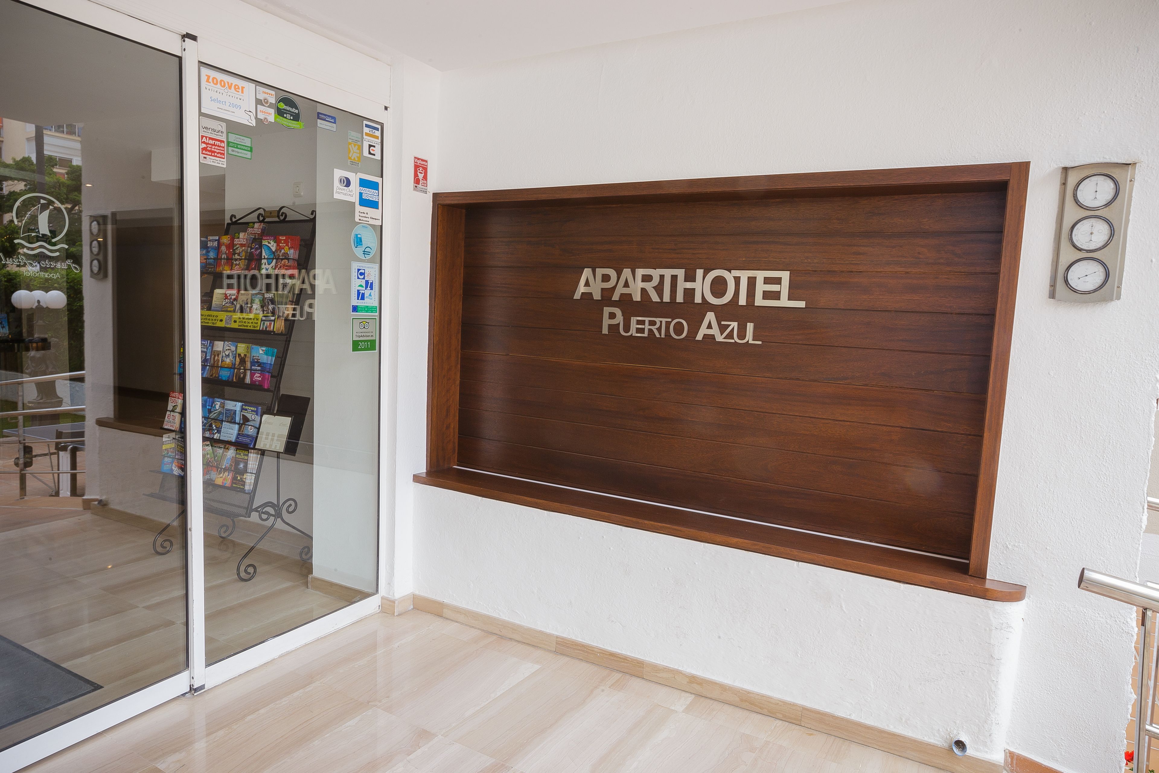 Un área de recepción con un letrero de madera que dice "APARTHOTEL PUERTO AZUL".