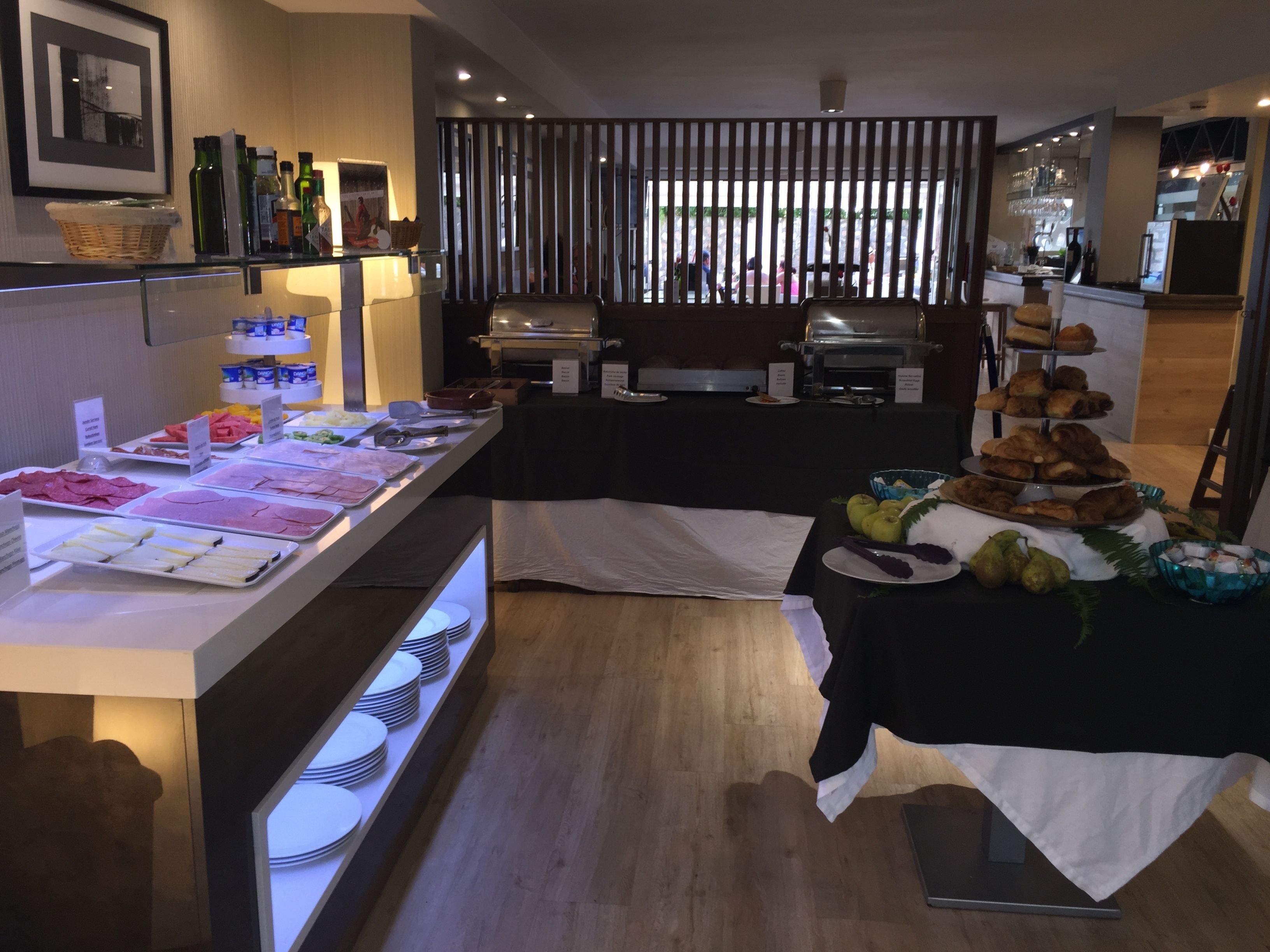 Un buffet proposant une variété de plats et un espace barbecue.