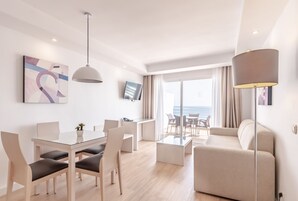 Een moderne hotelkamer met een zithoek, een bank en uitzicht op zee.