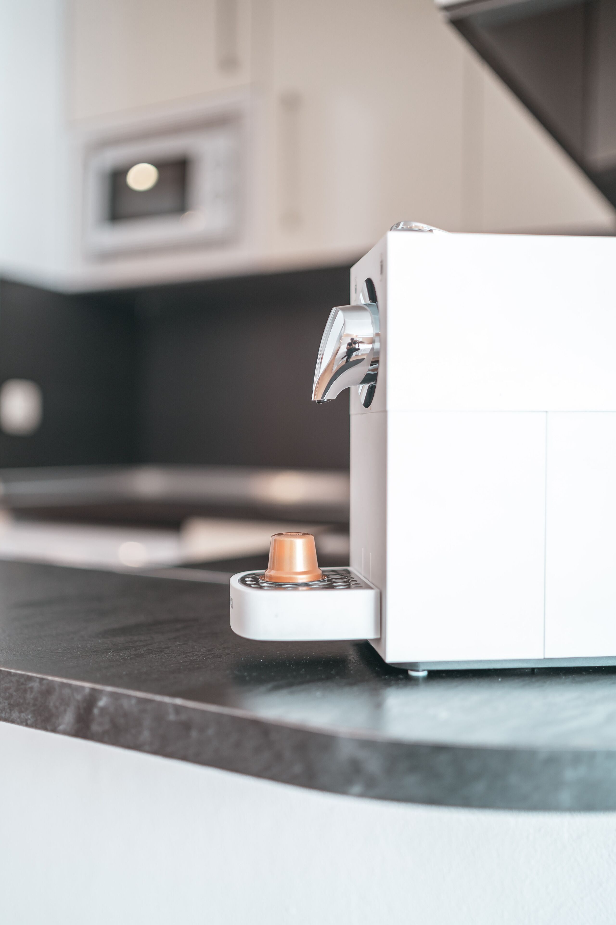 Una cafetera sobre una encimera de cocina con un diseño moderno.