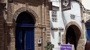 A building with a blue door, white walls, and a signboard. - Casa Lila & Spa (Essaouira)