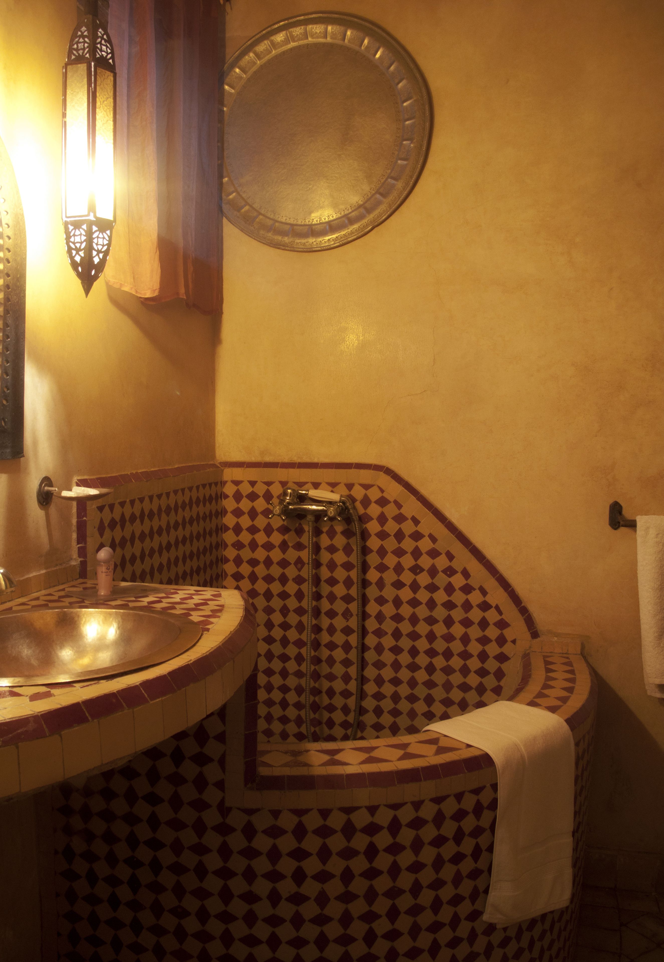 A bathroom with a sink, a mirror, and a shower.