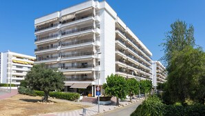 A multi-story residential building with balconies, a restaurant at the ground level, and a clear blue sky. - Suites del Mar Fenals (Lloret de Mar)