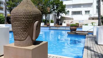Una piscina al aire libre de temporada, sombrillas