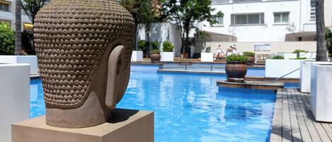 Una piscina al aire libre de temporada, sombrillas