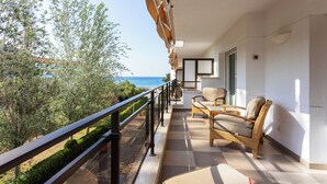 A balcony with wicker furniture, a view of the sea, and a clear sky. - Suites del Mar Fenals (Lloret de Mar)