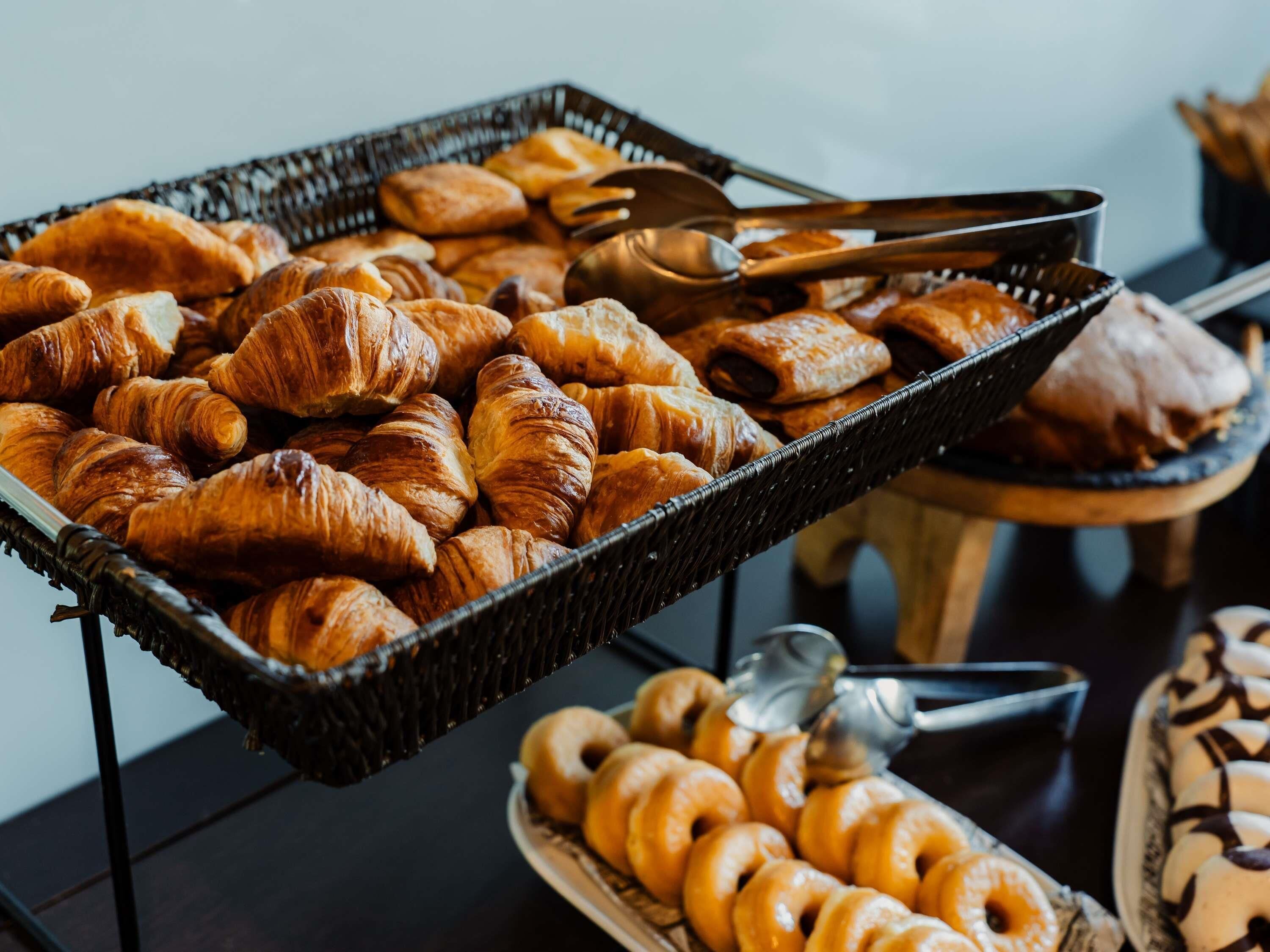 A buffet with croissants and donuts.