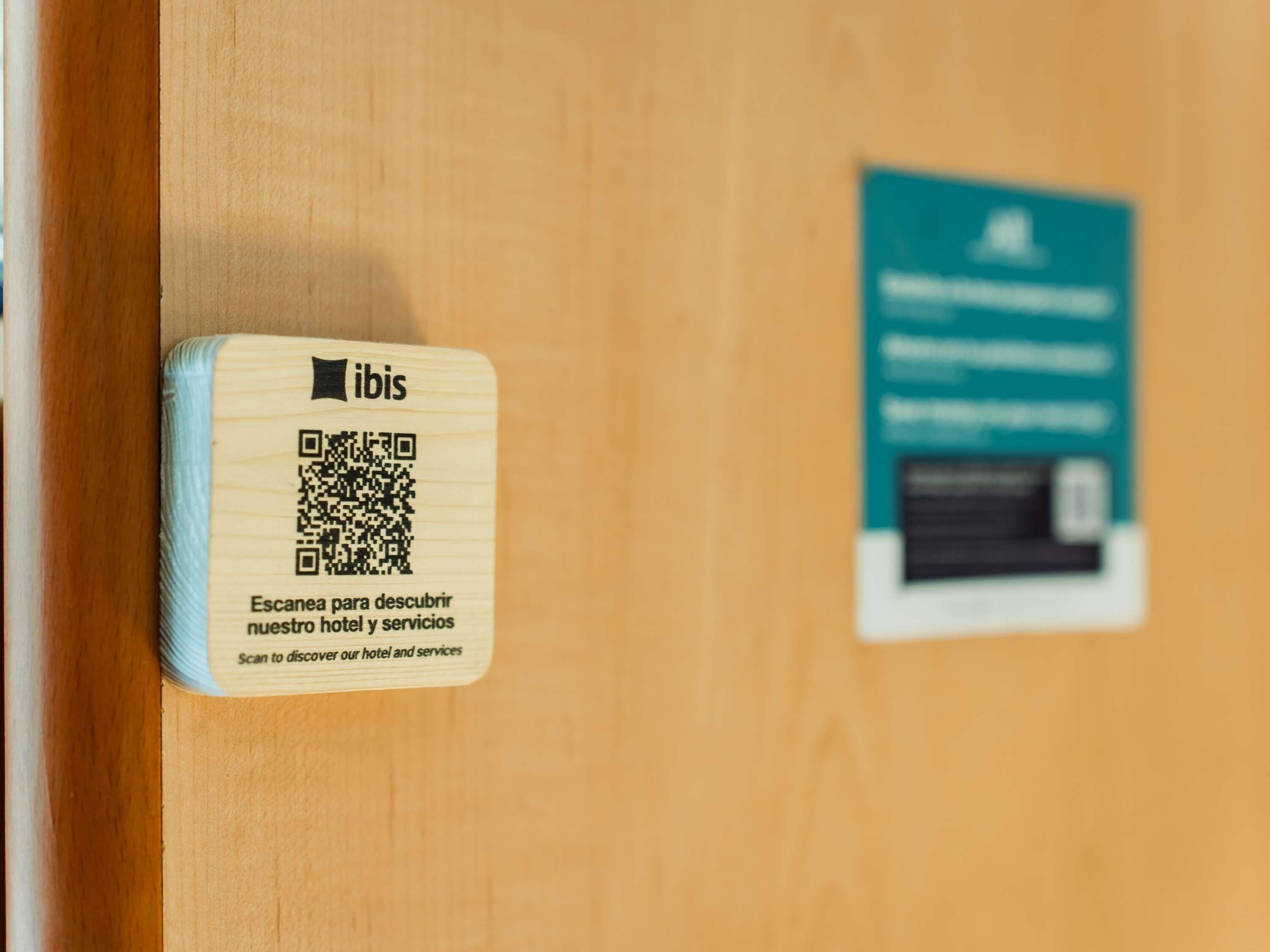 A wooden door with a QR code and a sign.