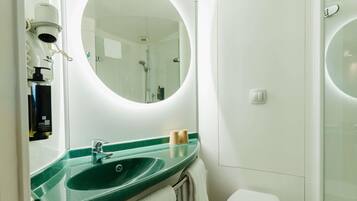Een badkamer met een groene wastafel, een wit toilet en een grote spiegel.