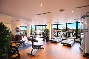 A gym with treadmills, exercise bikes, and weight machines.