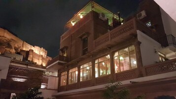 Um edifício tradicional com várias janelas e varandas, apresentando detalhes arquitetônicos elaborados.