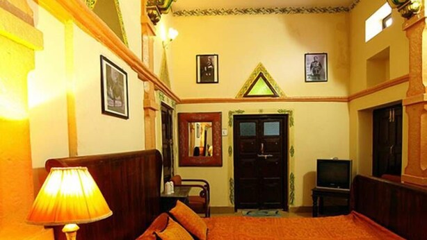 Une chambre d’hôtel avec un grand lit, un bureau, une lampe et un téléviseur.
