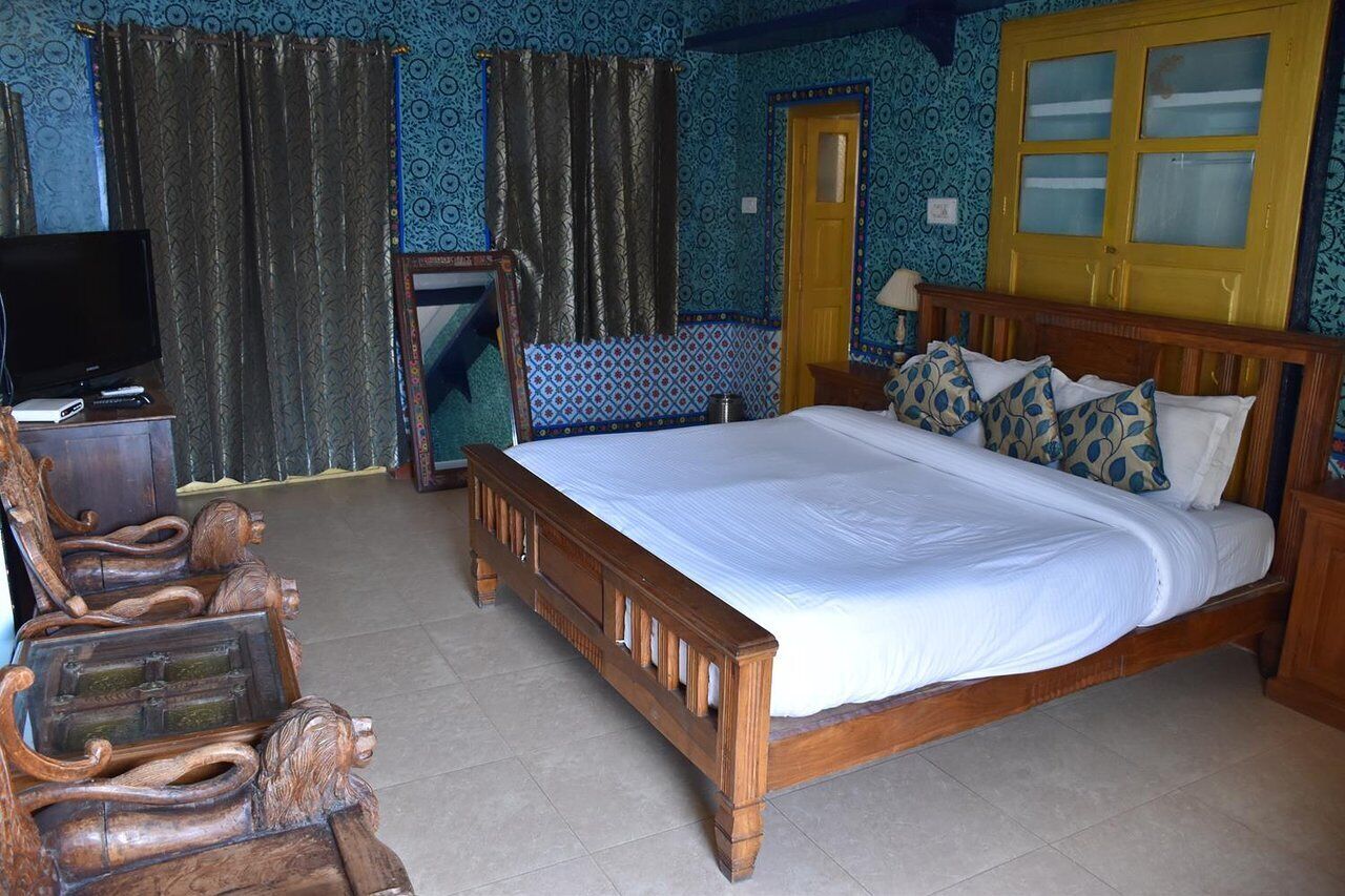 Un dormitorio con una cama grande, cabecera de madera y televisor sobre un mueble de madera.