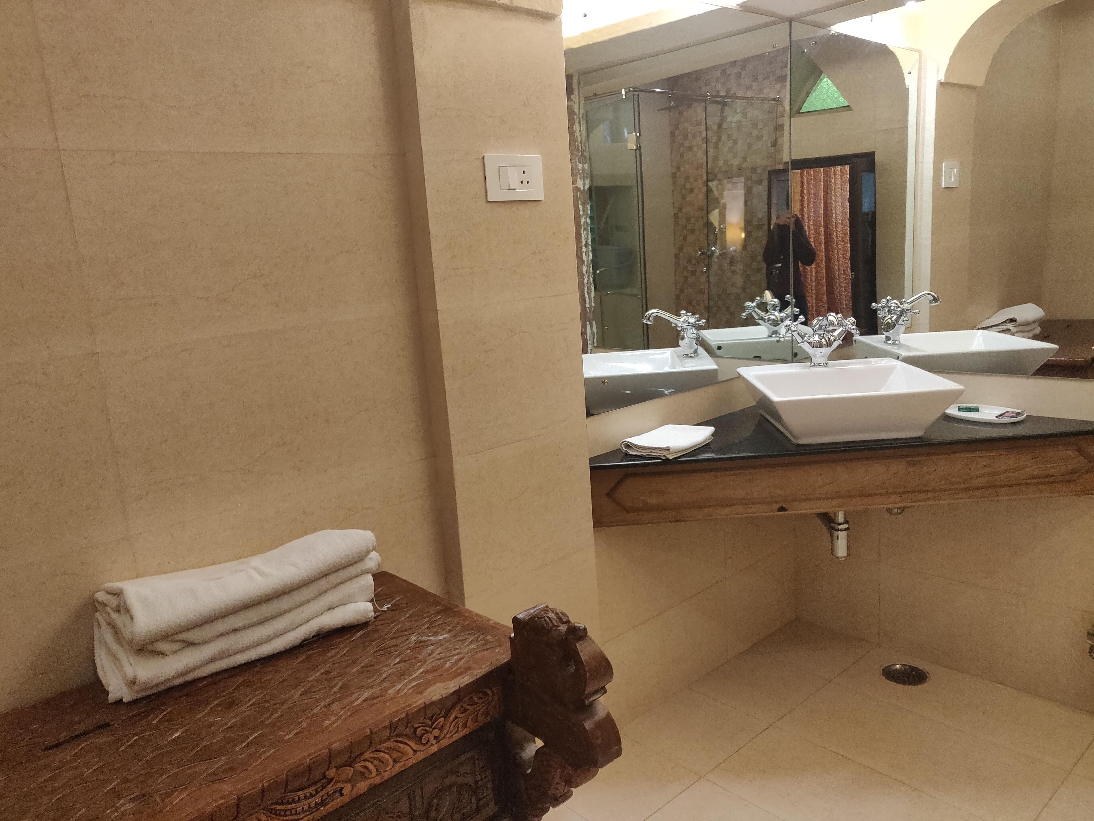 A bathroom with two sinks, a mirror, and a towel rack.