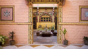 An ornate entrance with a tiled floor and potted plants. - Krishna Prakash Heritage Haveli (Jodhpur)