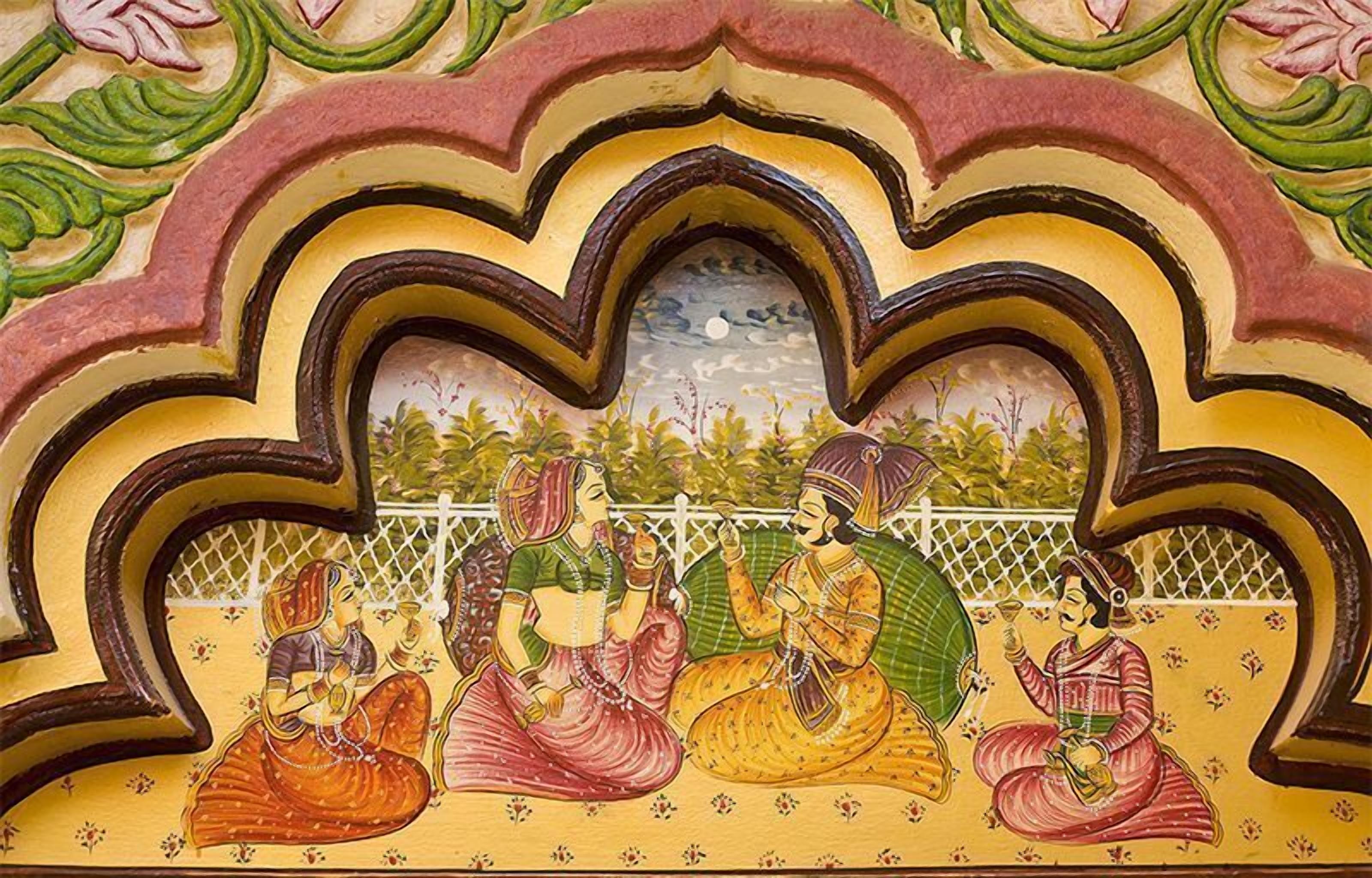 A mural with four women in traditional attire, seated and engaged in conversation.