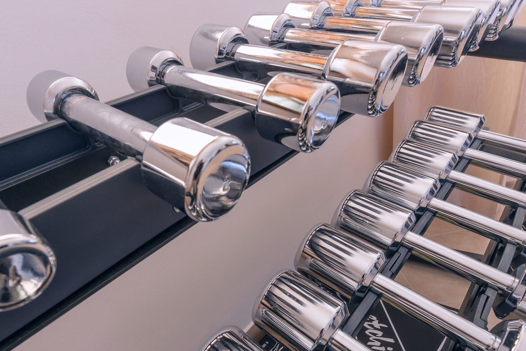 A row of black exercise equipment with chrome handles and weights.
