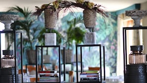 Een restaurant met tafels en stoelen, decoratieve vazen en een plafondlamp.