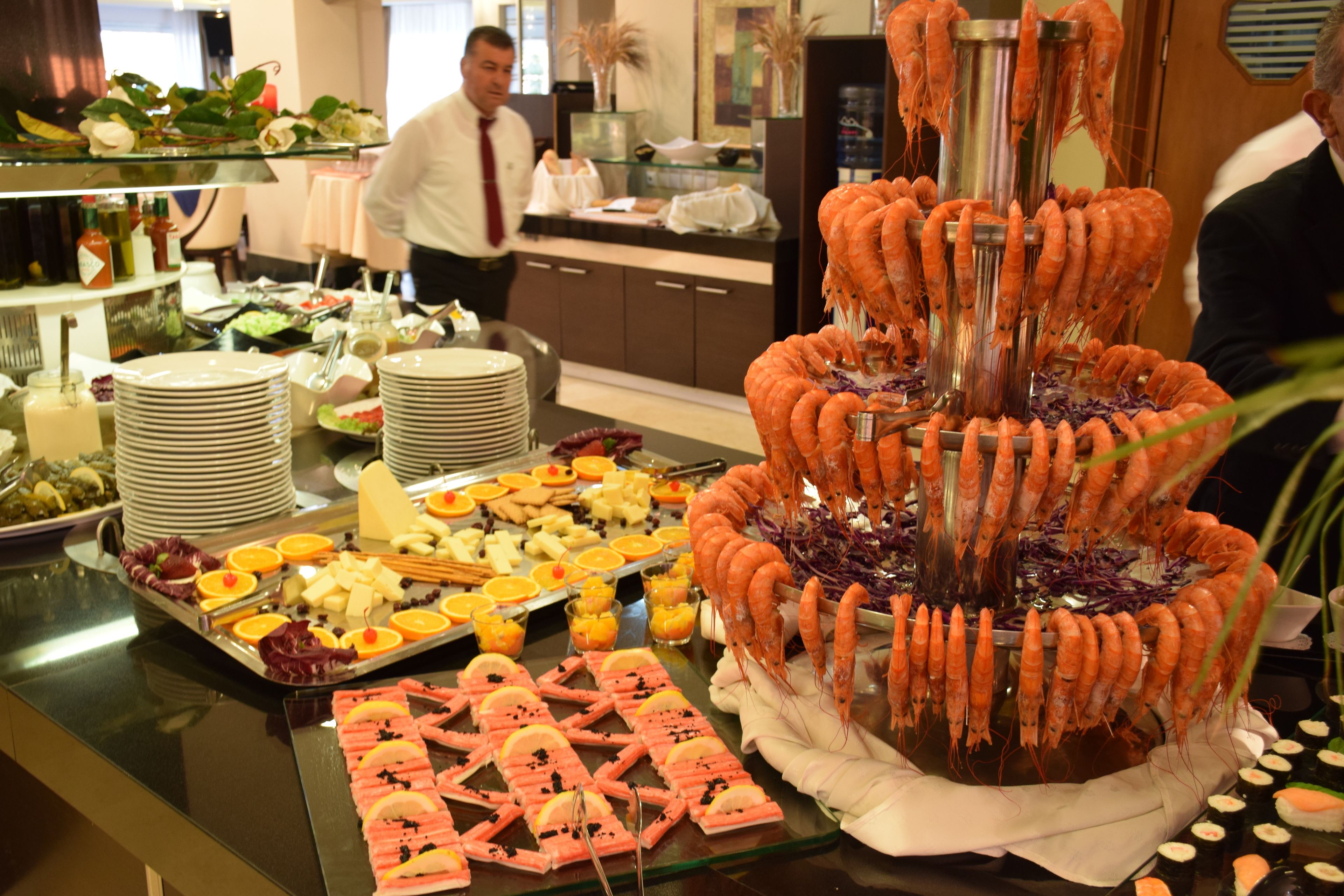 A buffet with various food items including shrimp, cheese, and fruits.