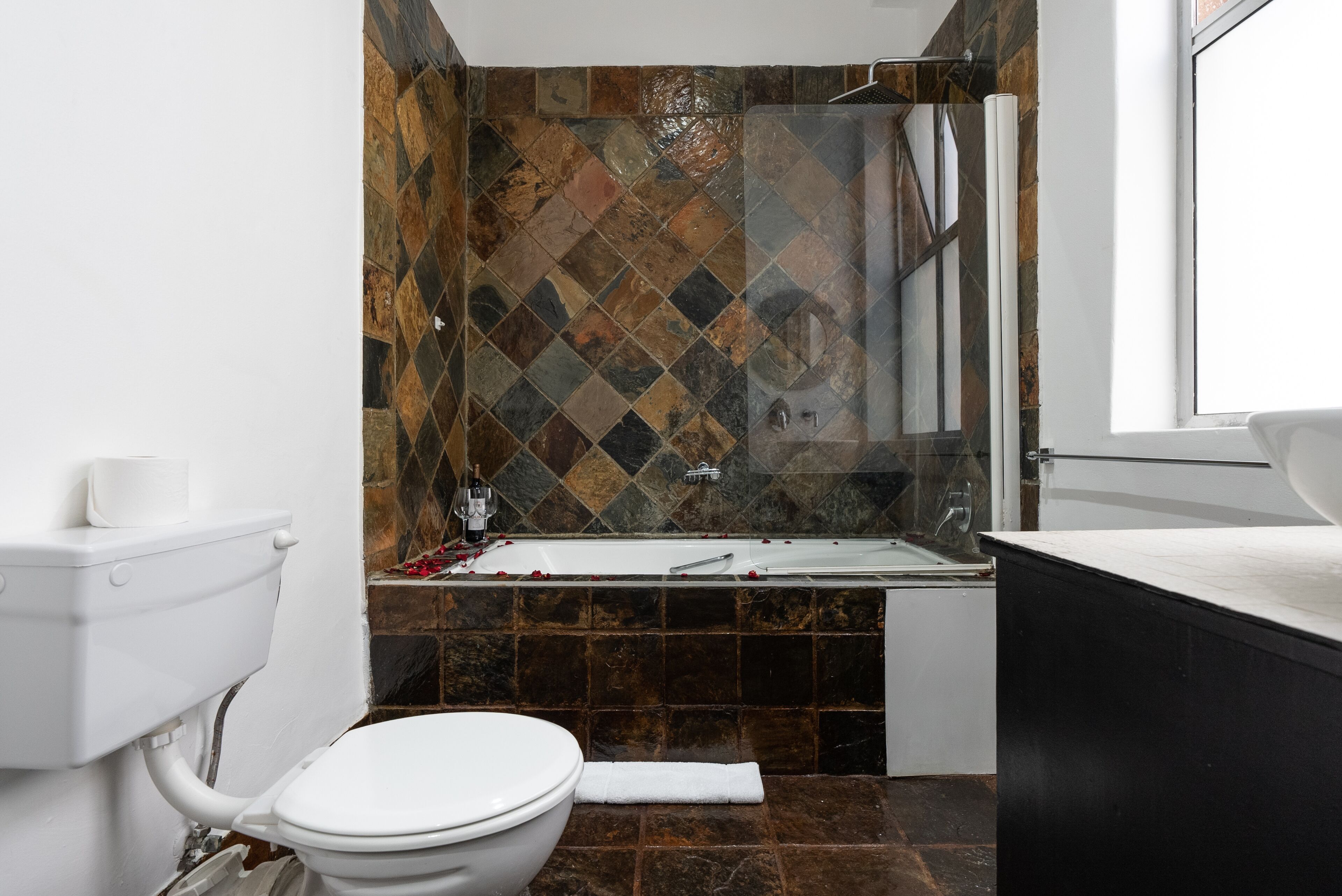 A bathroom with a toilet, a bathtub, and a sink.
