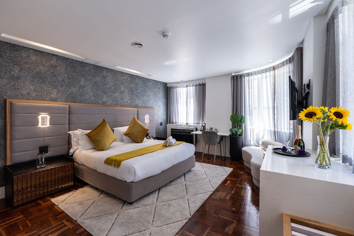 Ein modernes Hotelzimmer mit einem großen Bett, einem Schreibtisch und einer Sitzecke.
