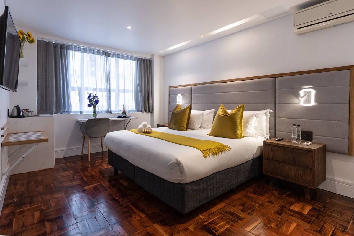 Ein modernes Hotelzimmer mit einem großen Bett, einem Schreibtisch und einem Stuhl.