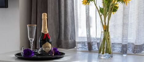 Een tafel met een champagnefles, een glas en een vaas met zonnebloemen.
