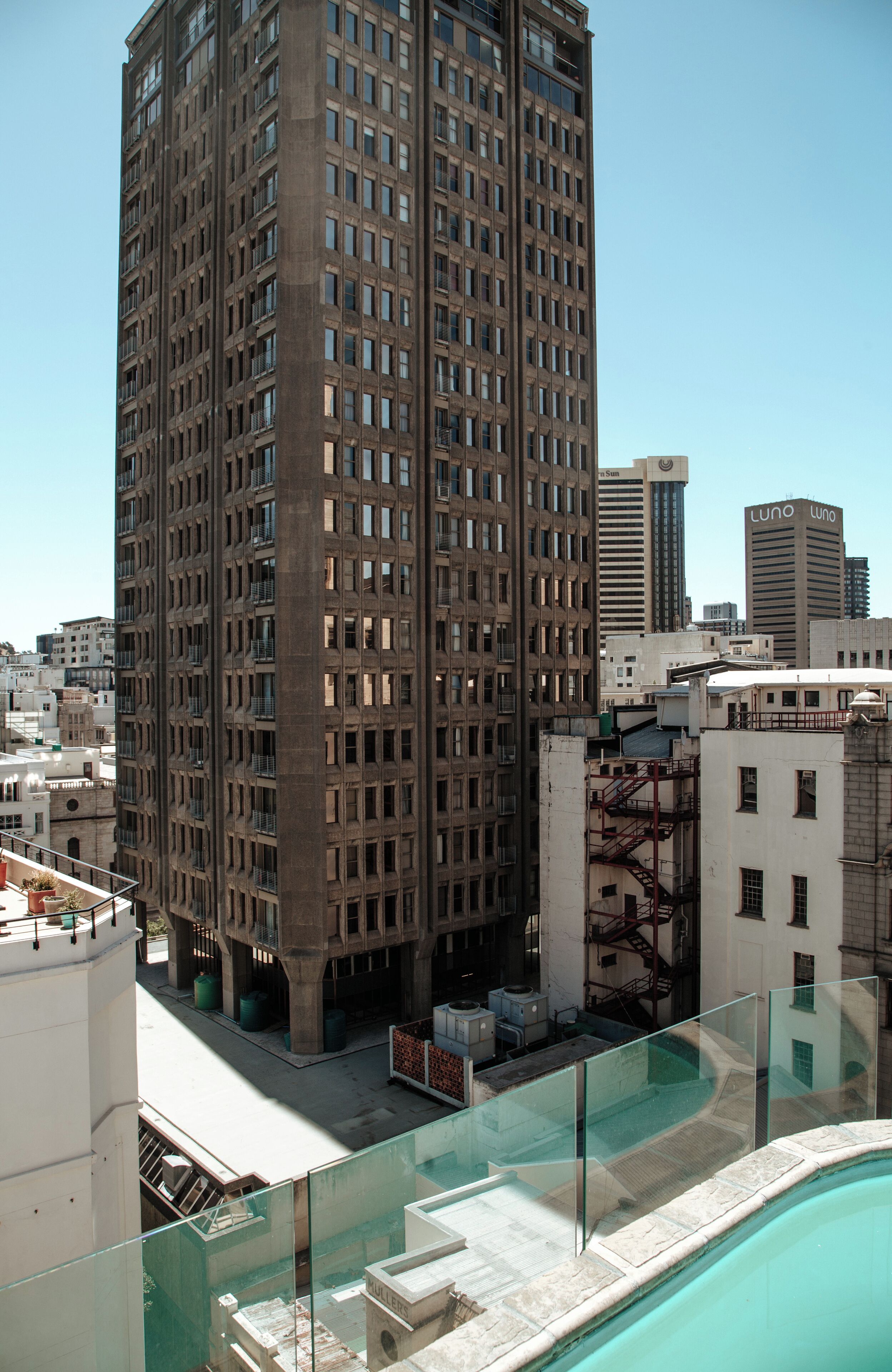 A high-rise building with a pool area visible below.