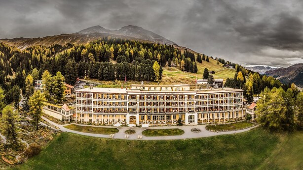 A large, multi-story hotel with a central courtyard, surrounded by forested hills and mountains. - Schatzalp Snow & Mountain Resort (Davos)