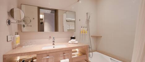 A modern bathroom with a sink, mirror, towel rack, and a shower area.