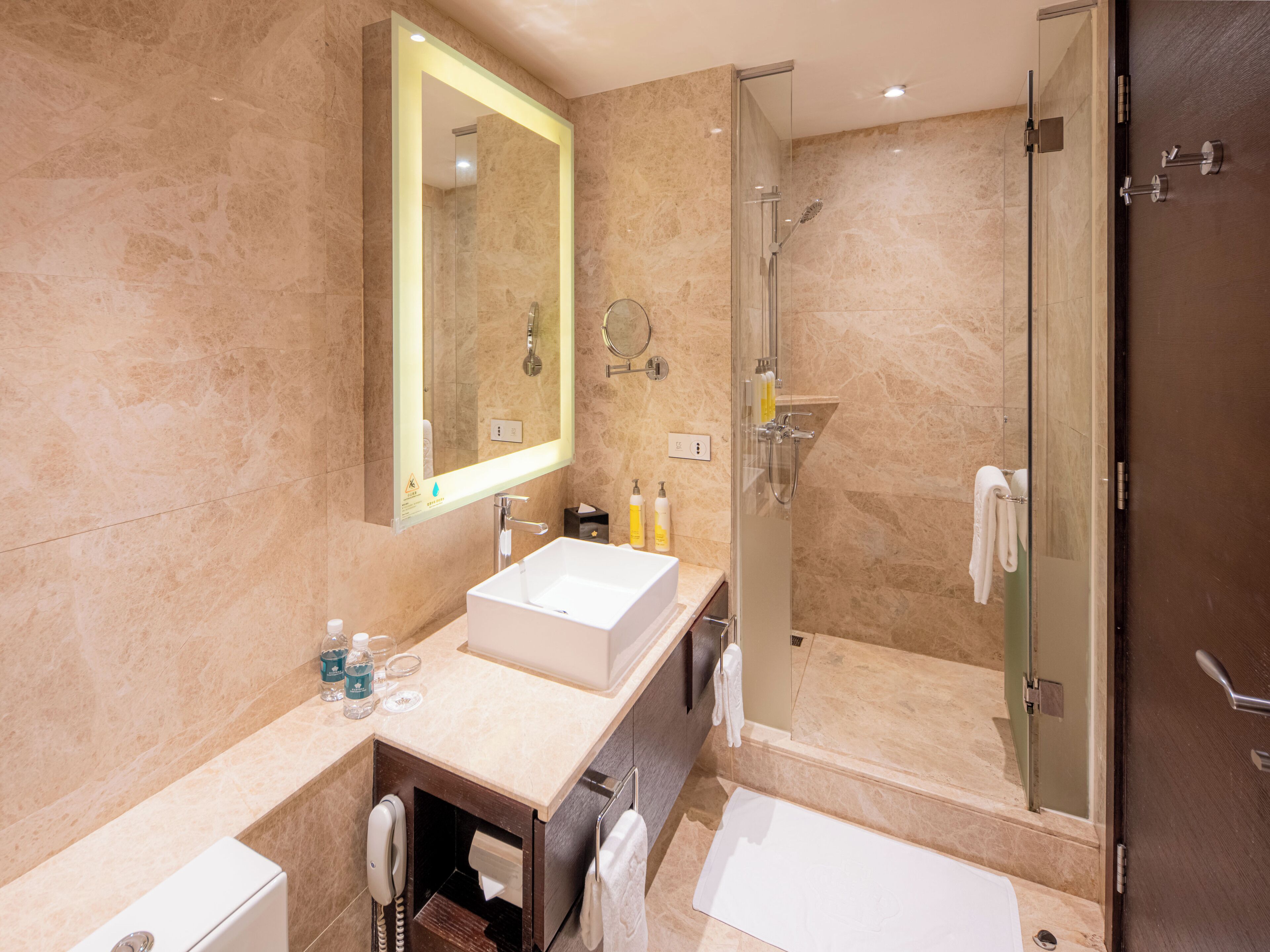 A modern bathroom with a large mirror, a sink, a shower, and a bathtub.