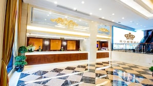 A hotel lobby with a reception desk, check-in counters, and a check-out area. There are potted plants and a chandelier. - Grand Emperor Hotel  (Macau)