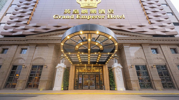 The Grand Emperor Hotel entrance with a prominent crown logo, a large circular entrance canopy, and classical architectural details. - Grand Emperor Hotel  (Macau)