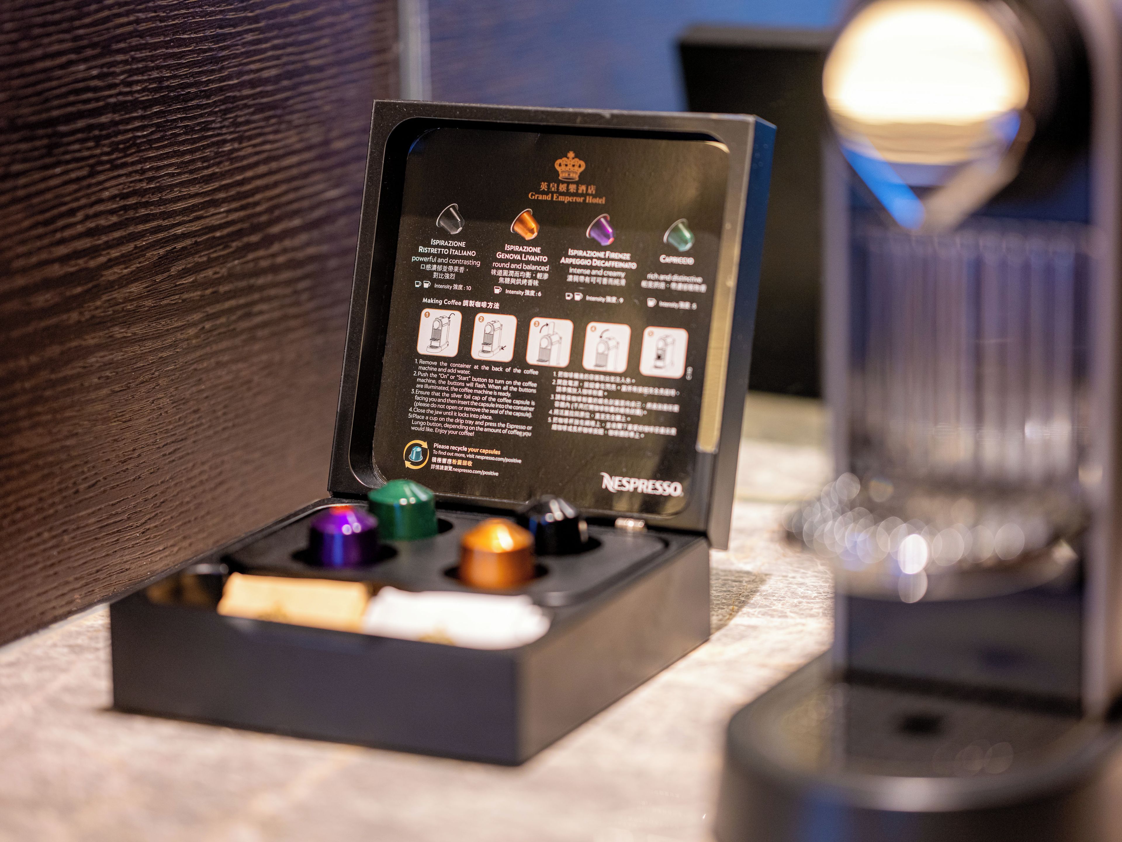 A Nespresso coffee machine with instructions and capsules on a table.