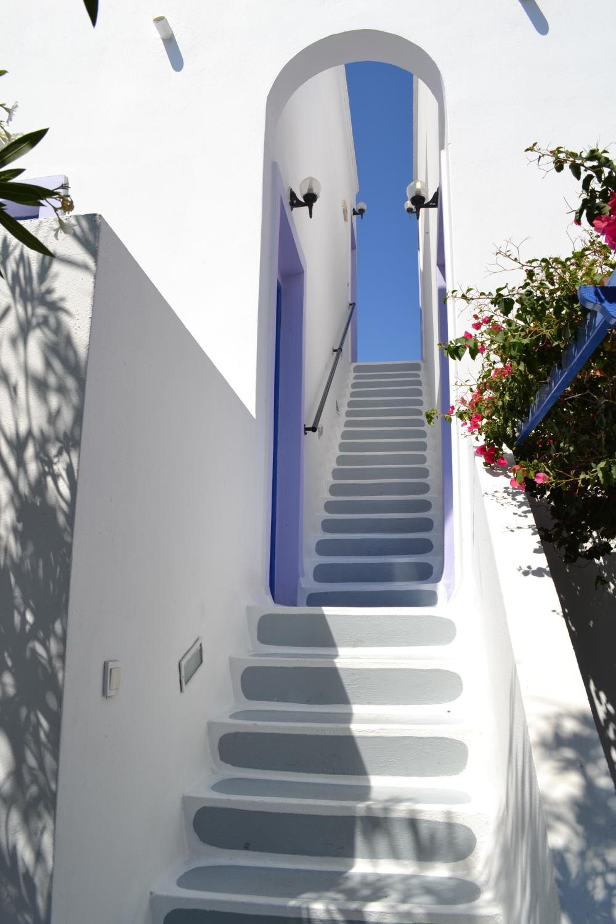 A white building with a blue staircase leading to a door.