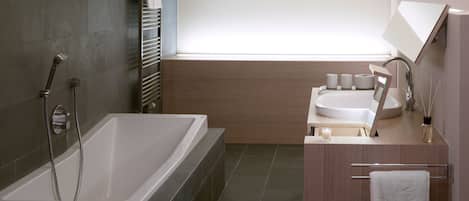 Un baño moderno con bañera, dos lavamanos y una ventana.