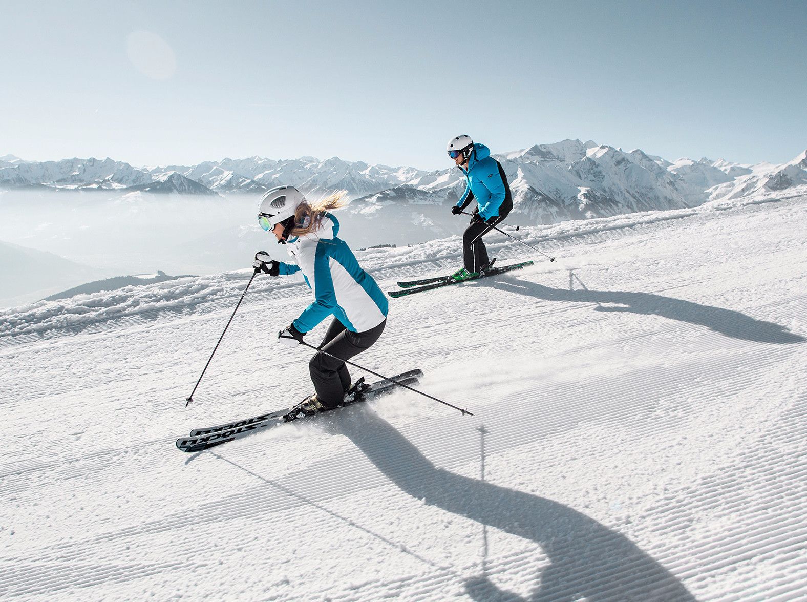 Une piste de ski enneigée avec deux skieurs en mouvement.