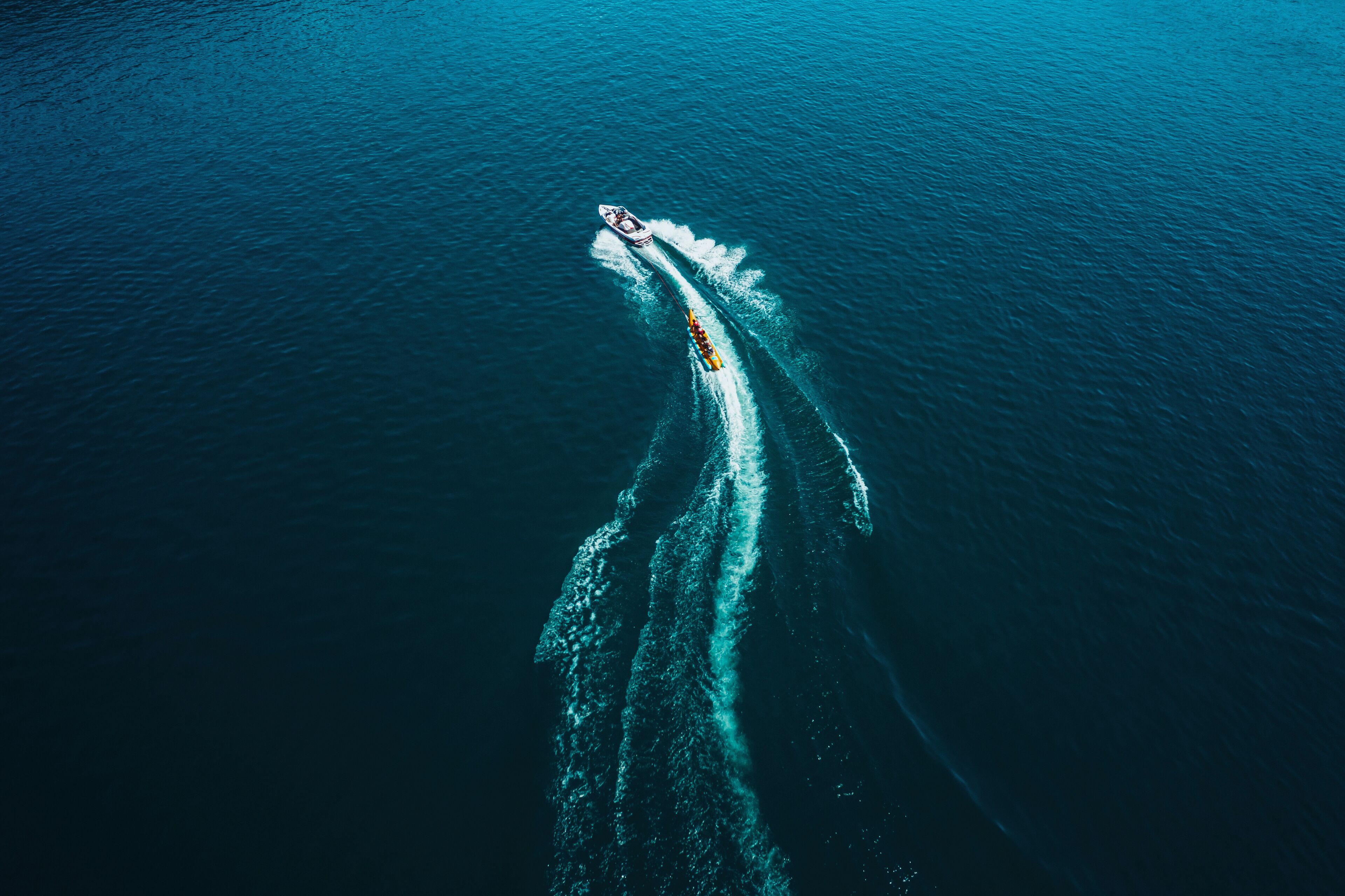 An aerial view of a boat creating a wake in the ocean.
