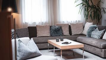 Un salon moderne avec un canapé d’angle, une table basse et une lampe.