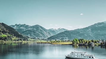 Ein Boot auf einem ruhigen See vor einer Bergkulisse.
