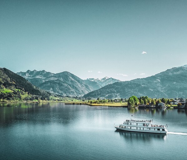 A boat on a calm lake with mountains in the background.