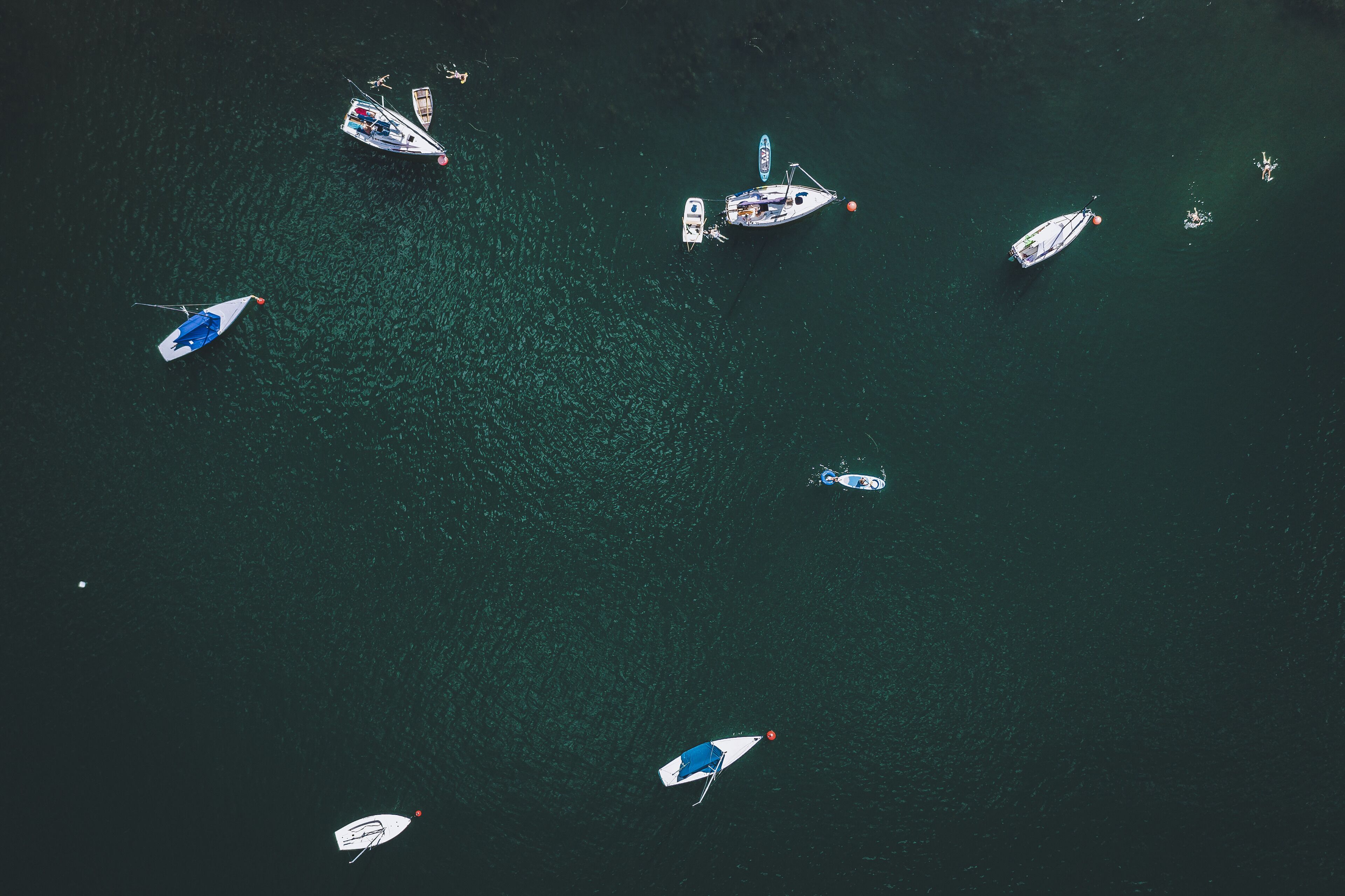An aerial view of a marina with several boats docked and anchored.