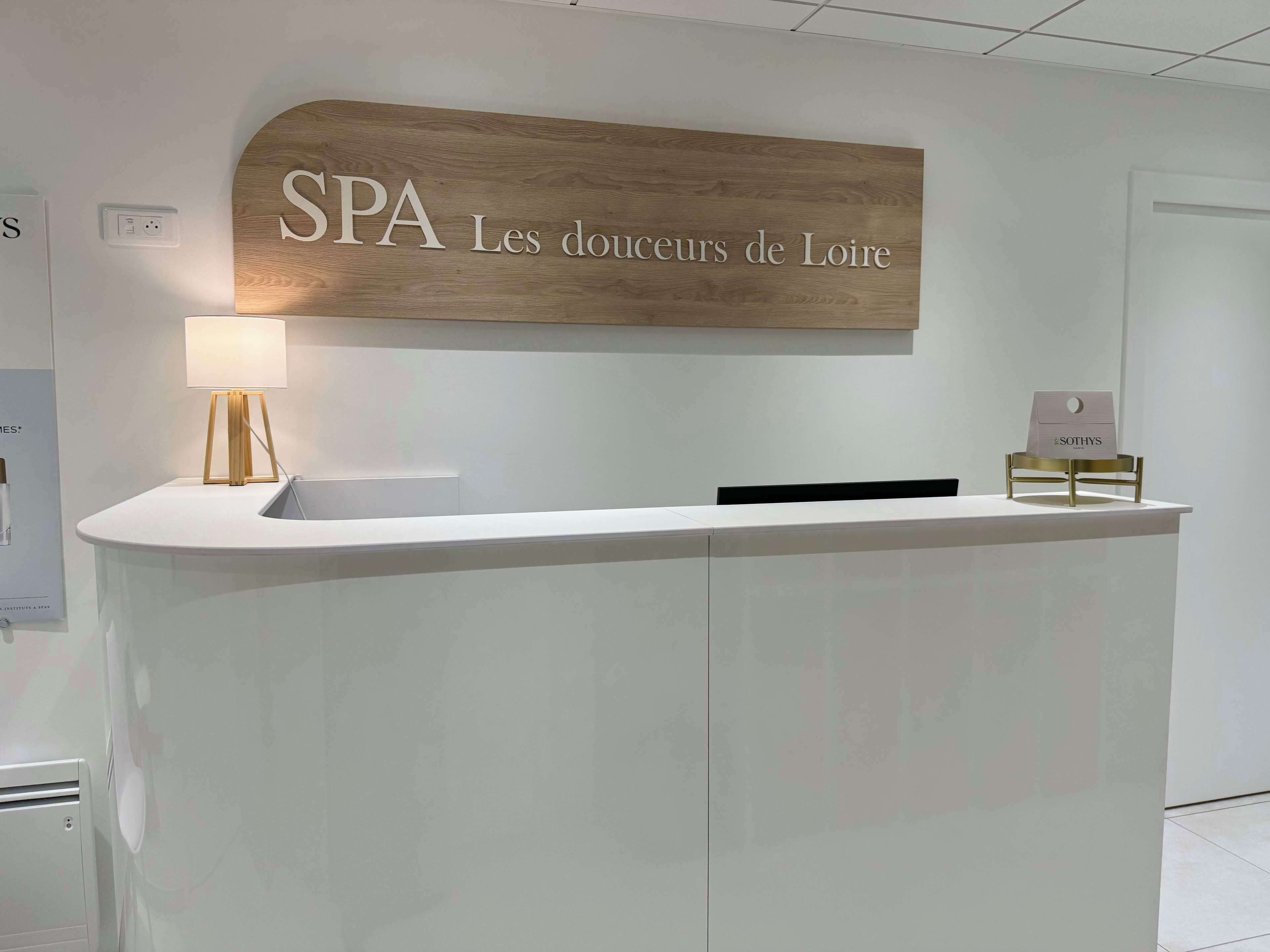 A reception desk with a sign above it that reads "SPA Les douceurs de Loire".